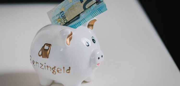 A white piggy bank with a €20 note inserted, symbolizing savings.