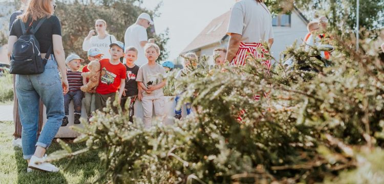Children and adults participating in an outdoor educational activity surrounded by nature.