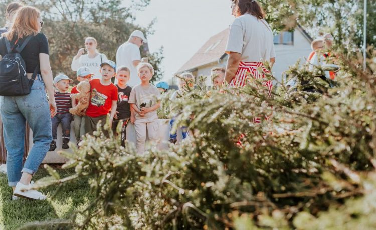 Children and adults participating in an outdoor educational activity surrounded by nature.